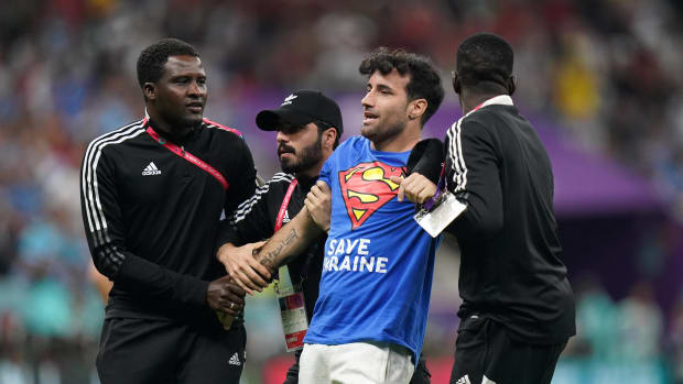 Security staff at Lusail Stadium pictured escorting a pitch invader off the field during a World Cup game between Portugal and Uruguay in November 2022